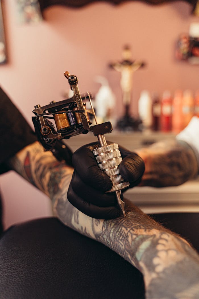 Intense close-up of a tattoo artist working on a client's arm in a tattoo studio.